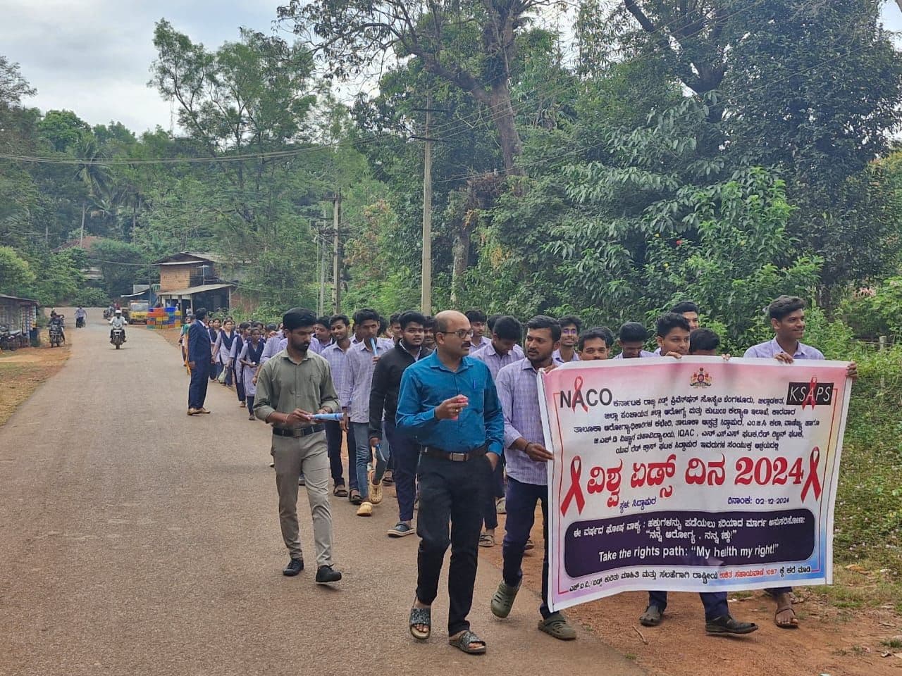 Students on an awareness rally along the tree-lined road