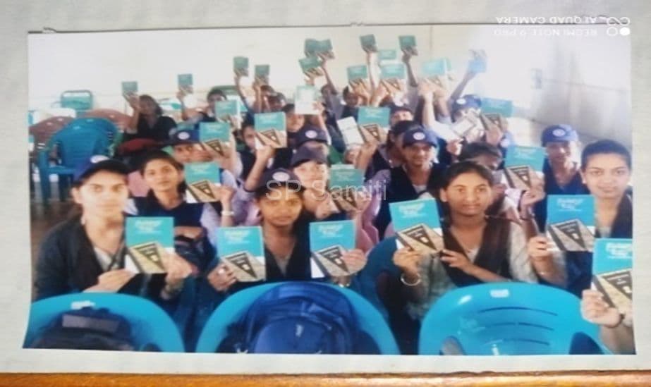 Students holding up books at a department programme
