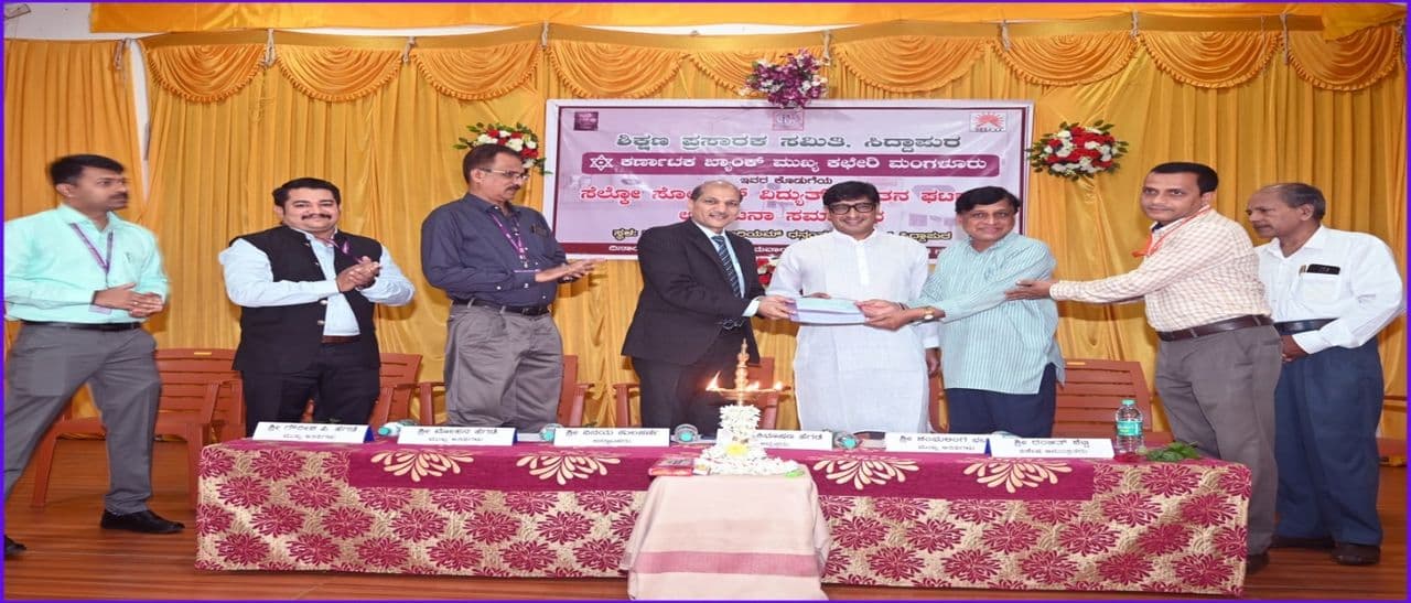 Sri Vinay Kulakarni of Karnataka Bank handing over the cheque to Sri Mohan Hegde, CEO of SELCO Solar Light