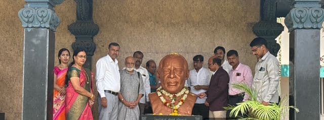 College staff offering flowers at the statue of Shri Ramakrishna Hegde