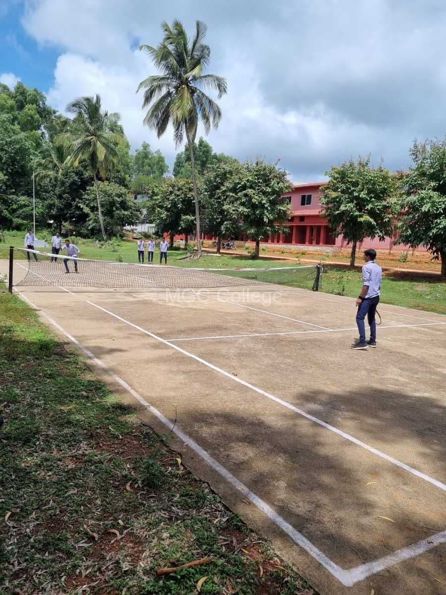 Students playing on the outdoor court under coconut palms